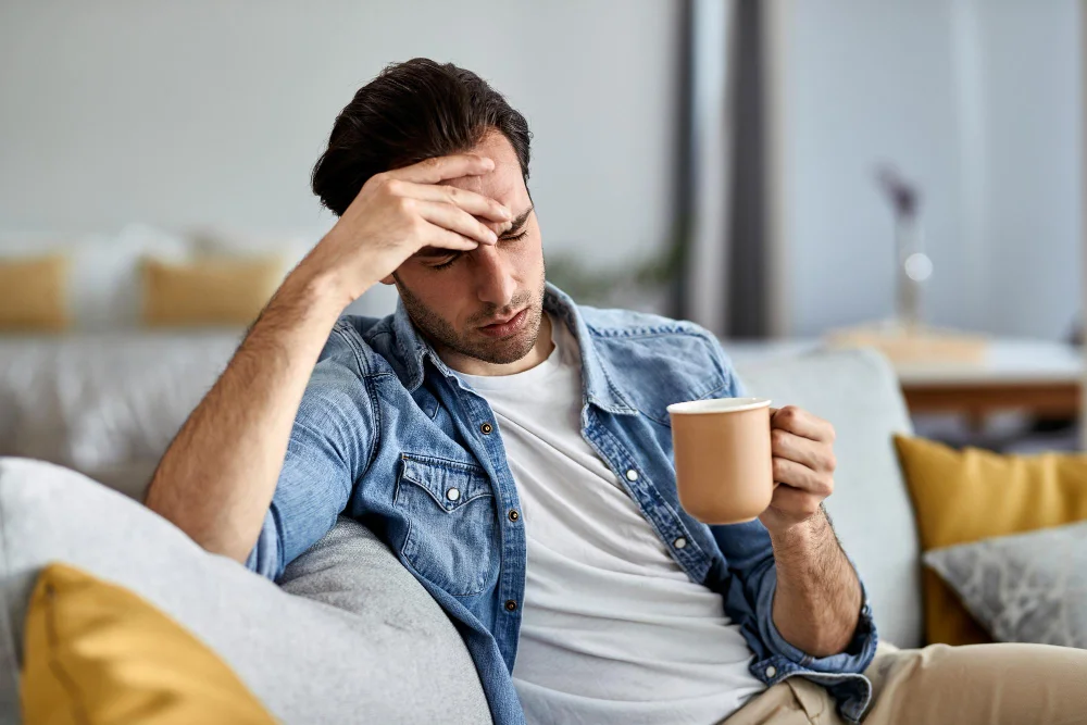 Hombre cabizbajo tomando un café