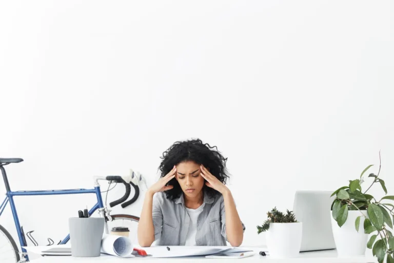 Mujer estresada en el trabajo sujetándose la cabeza